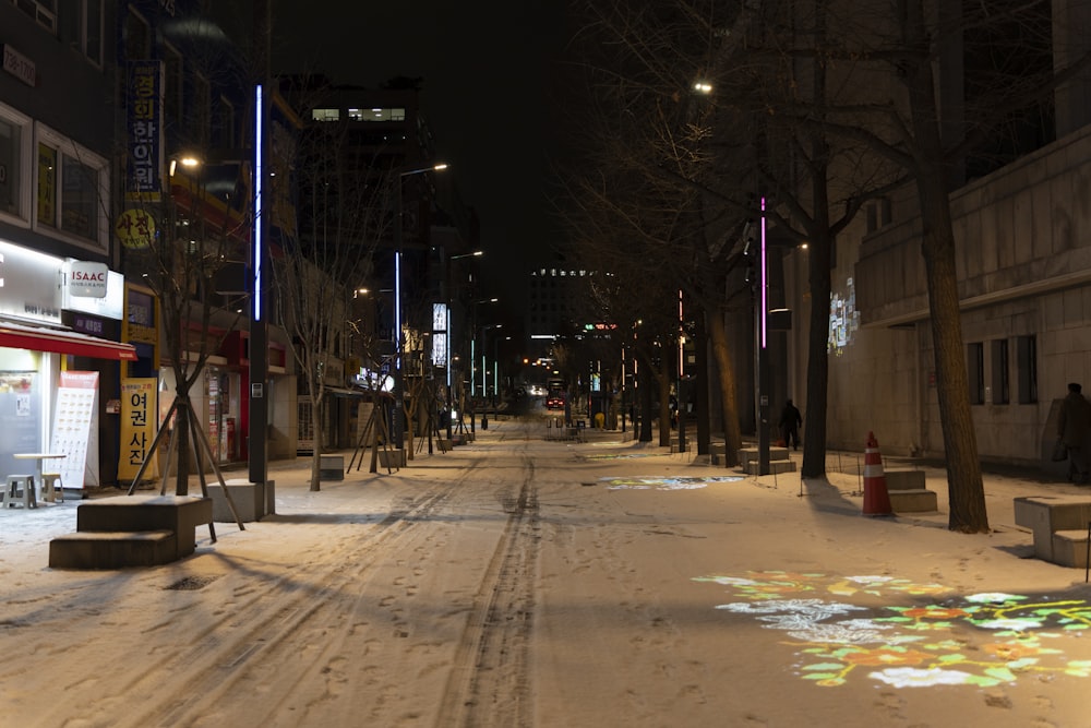 a city street is covered in snow at night