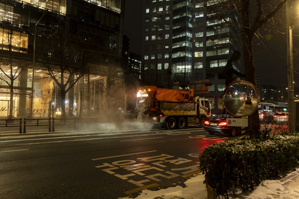 a truck driving down a street next to a tall building