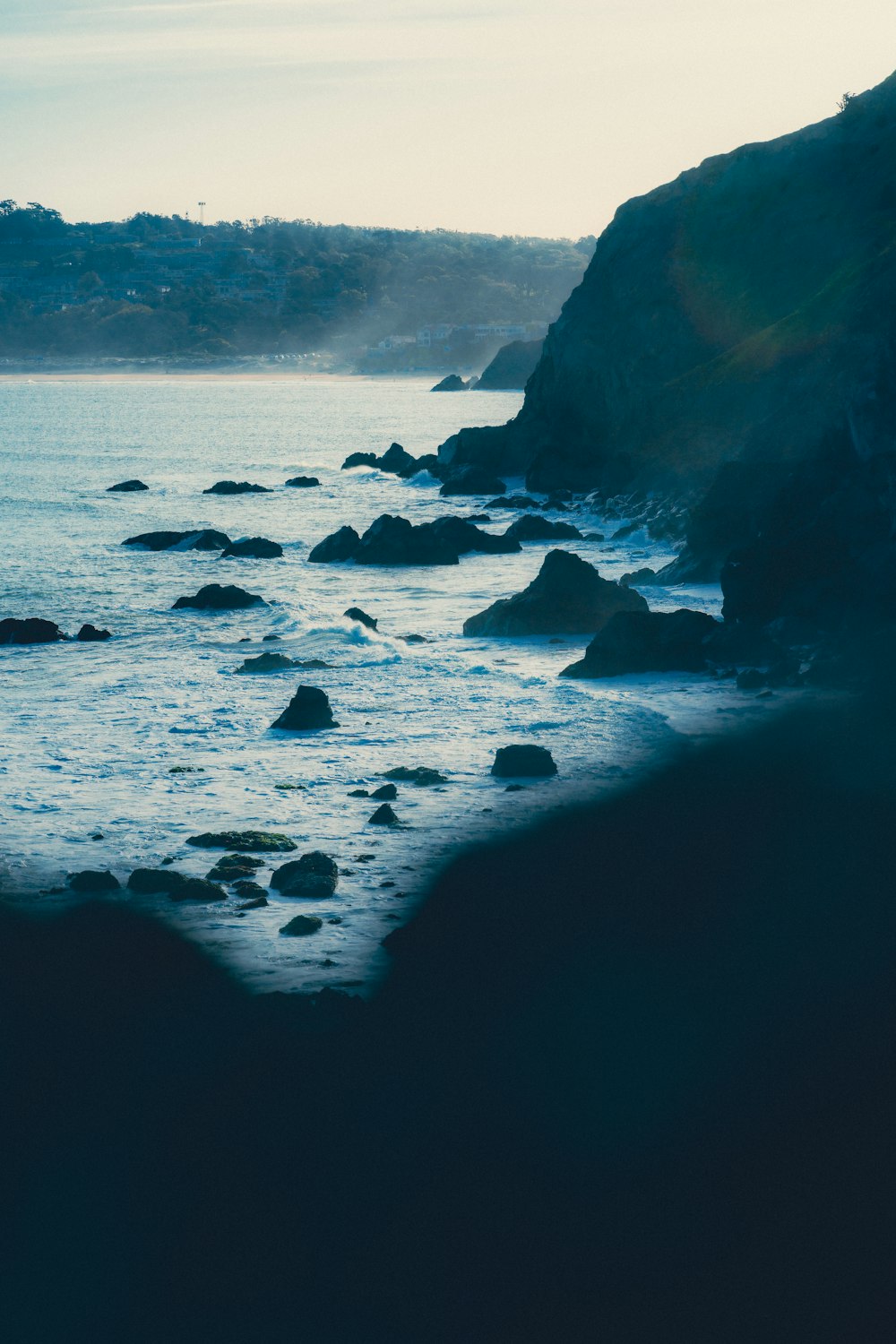 a body of water sitting next to a rocky shore