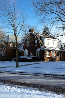 a red brick house with snow on the ground