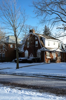 a red brick house with snow on the ground
