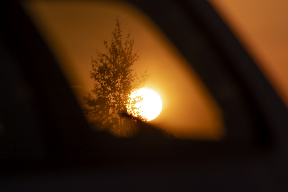 a sunset seen through a rear view mirror