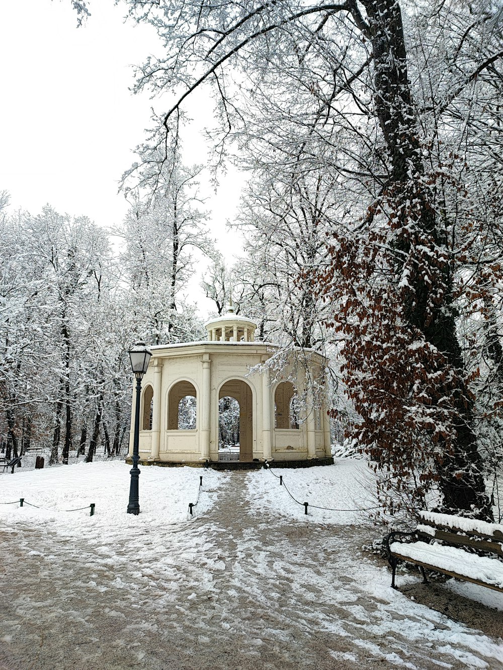 a white gazebo surrounded by snow covered trees