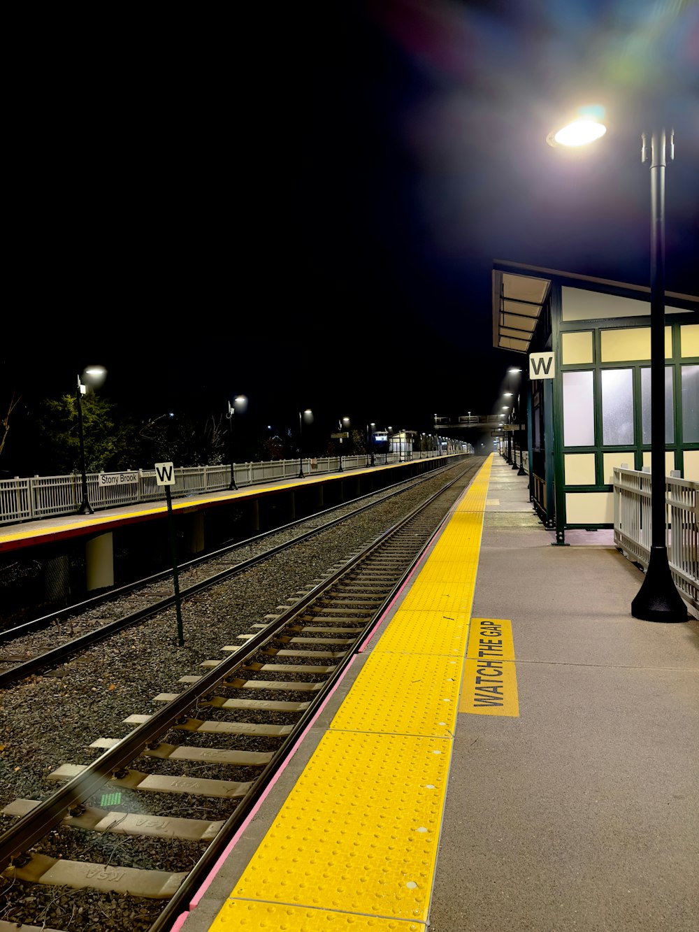 a train station at night with the lights on