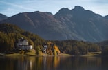 a house on a lake surrounded by mountains