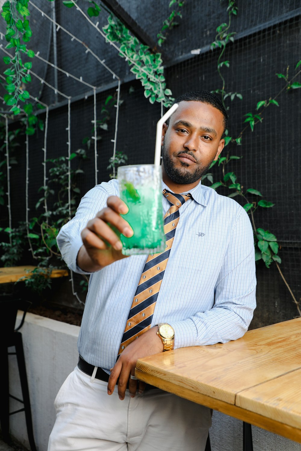 a man in a tie holding a drink