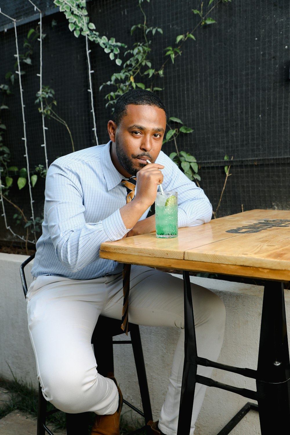 a man sitting at a table with a drink