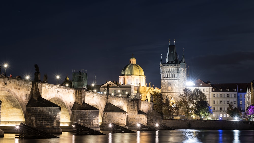 uma vista noturna de uma cidade com uma ponte e edifícios