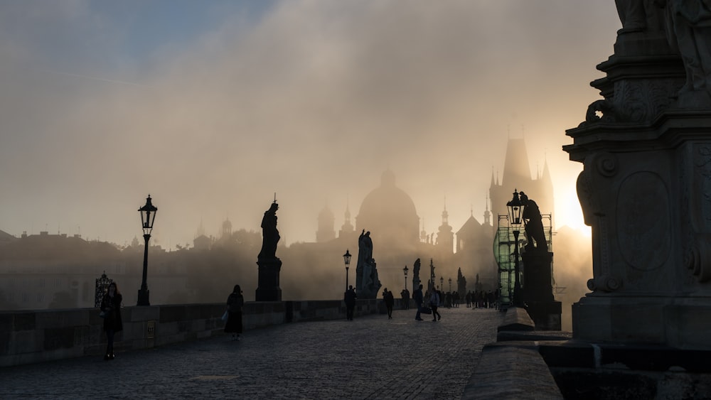 a foggy city street with a clock tower in the distance