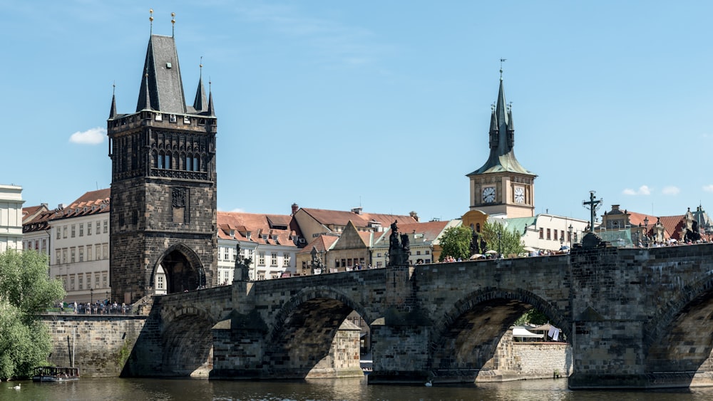 a stone bridge with a clock tower in the background
