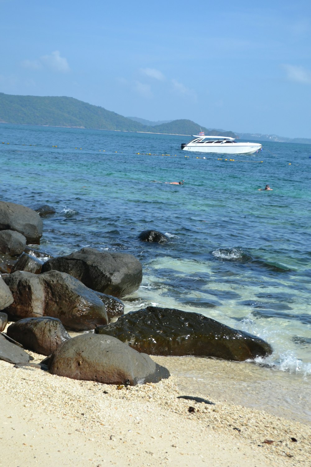 a boat is in the water near some rocks