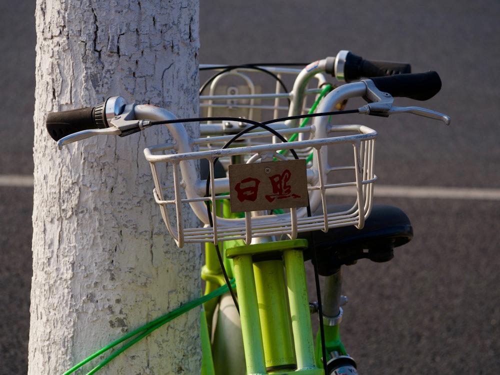 a bicycle with a basket attached to a tree