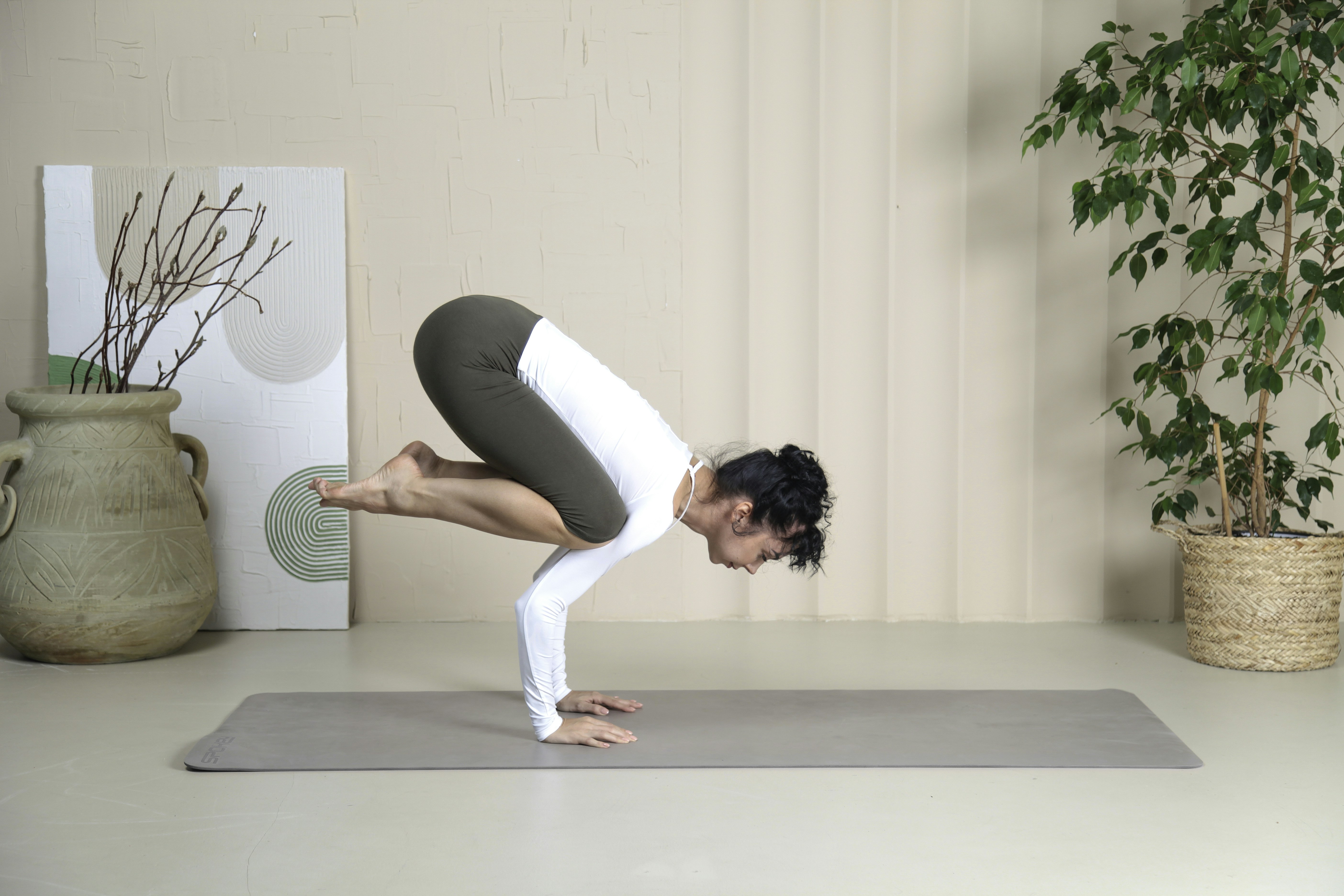 Une femme fait une pose de yoga sur un tapis