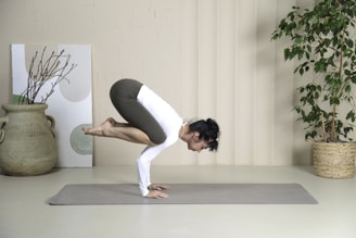 a woman is doing a yoga pose on a mat