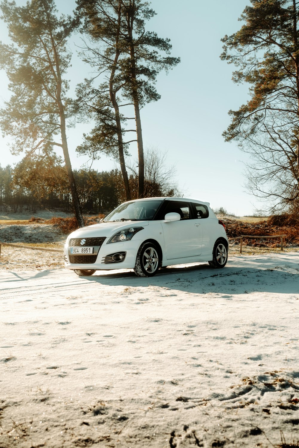 a small white car parked in the snow