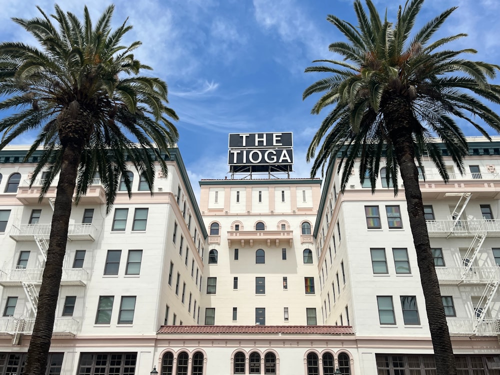 a hotel with palm trees in front of it