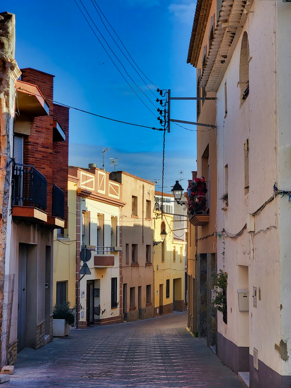 a narrow street with buildings and a traffic light