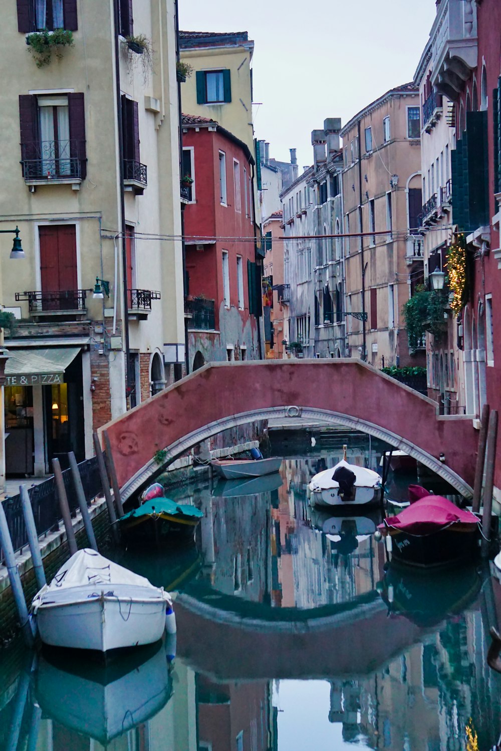 a bridge over a canal with boats in it