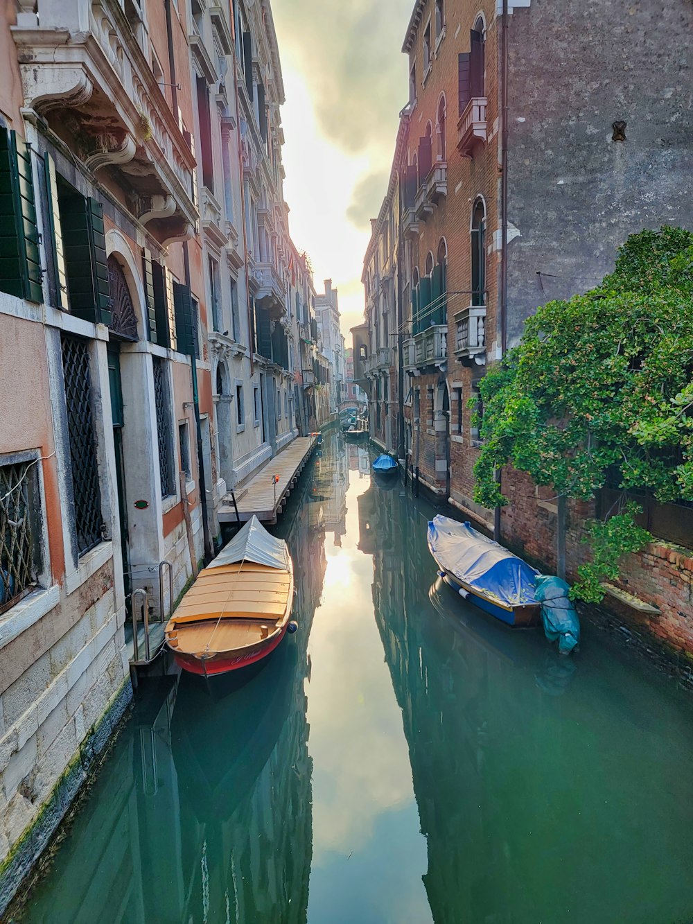 a narrow canal with several boats in it