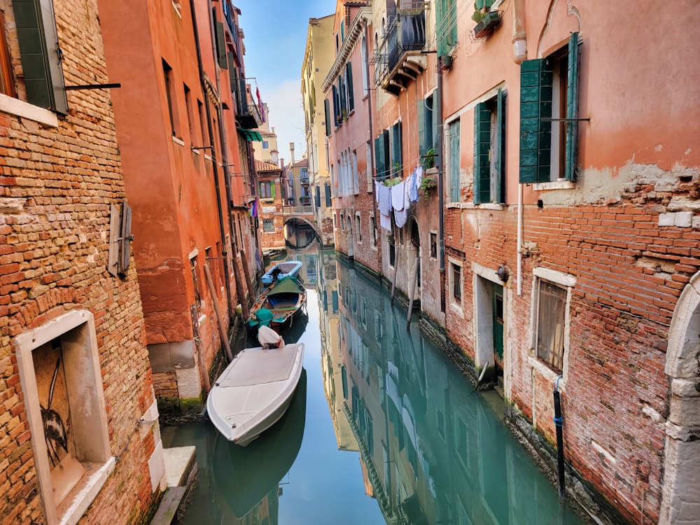 a small boat is parked in a narrow canal