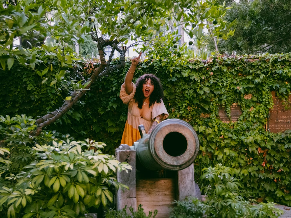 une femme en robe jaune debout dans un jardin