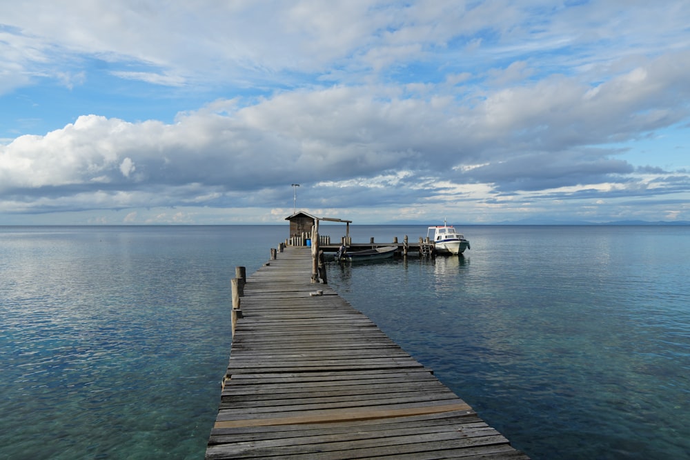 a dock with a house and a boat in the water