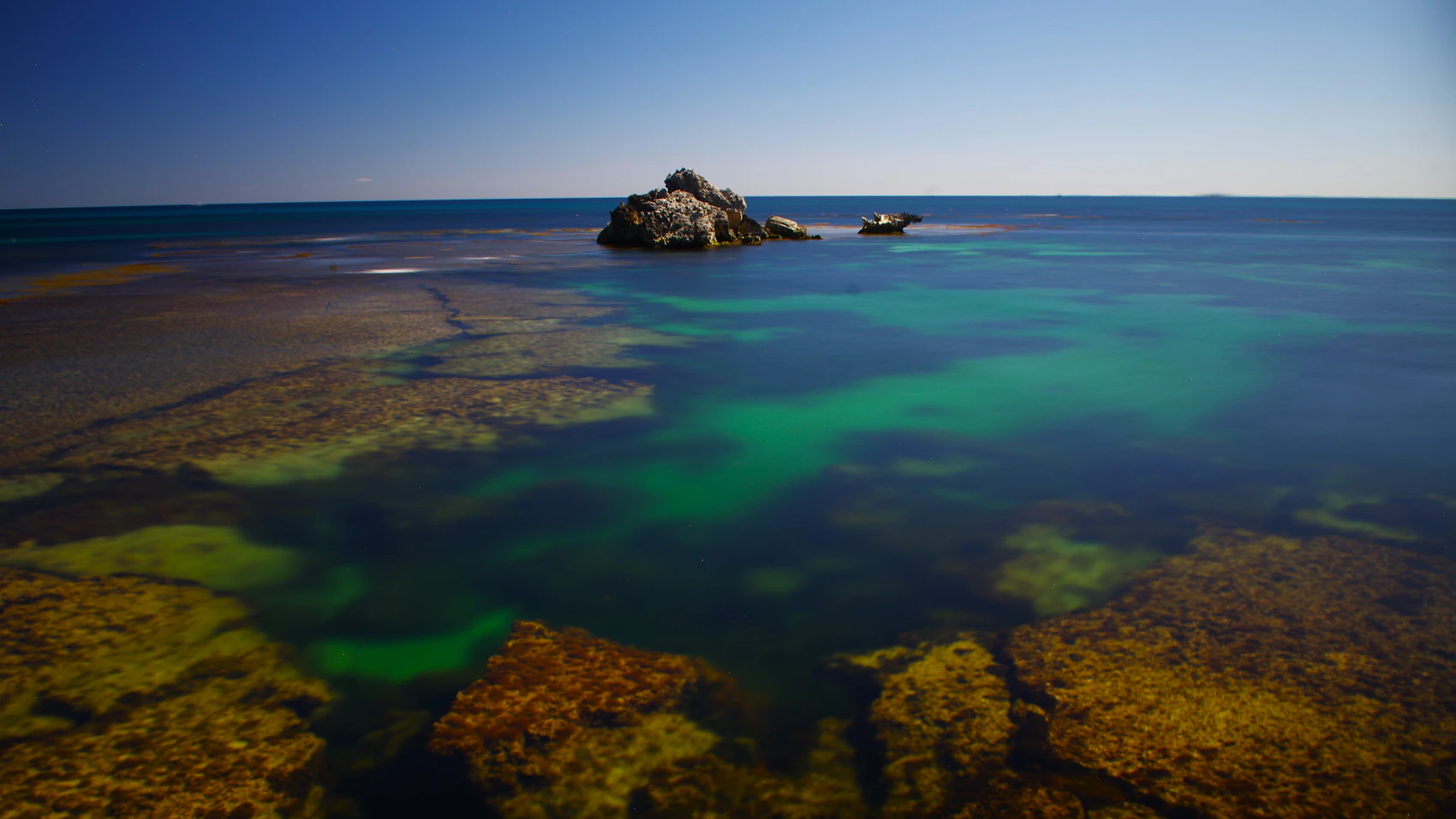 Calm turquoise water and rocky shore on Rottnest Island