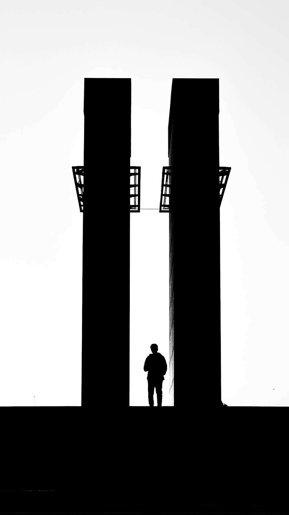 a man standing in between two tall buildings