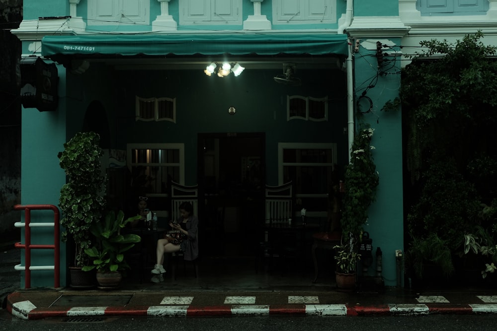 a person sitting on a bench in front of a building