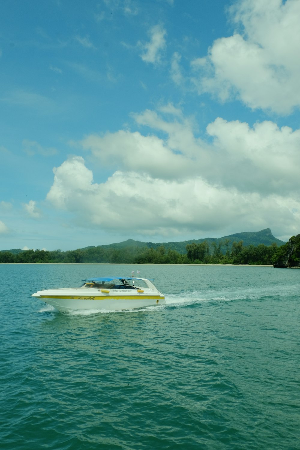 a white boat traveling across a large body of water