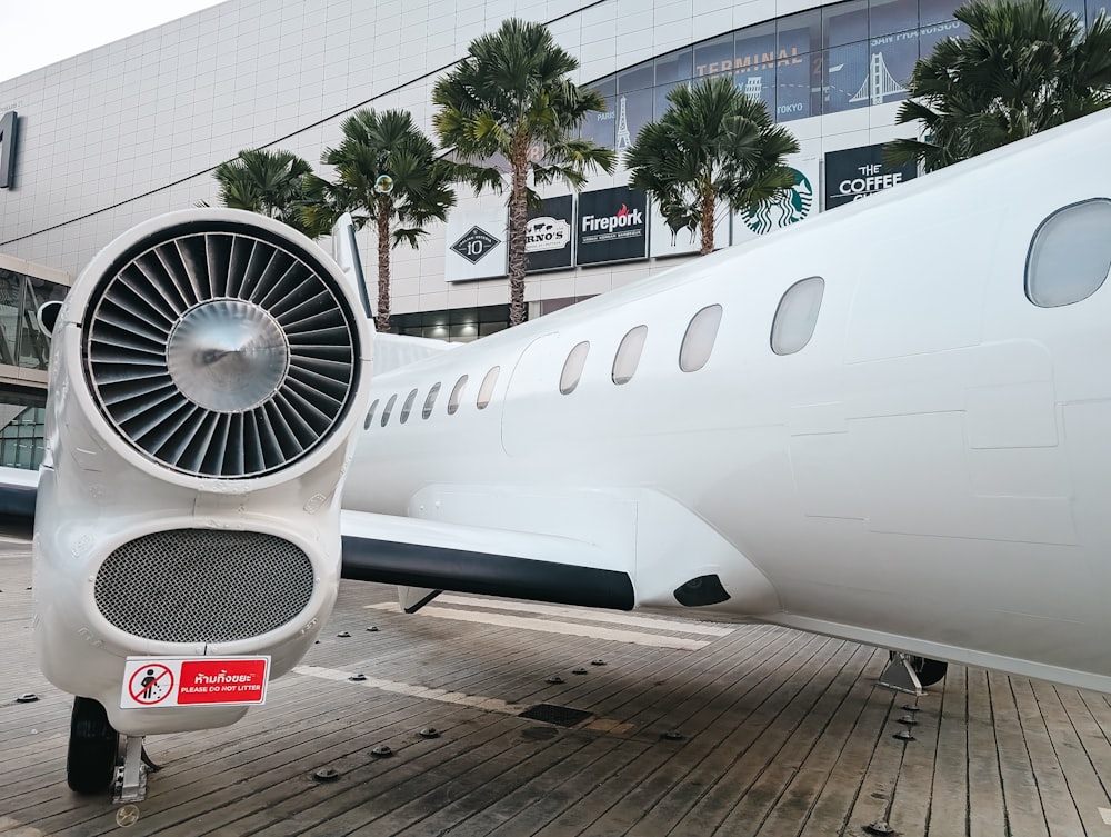 a large white airplane sitting on top of a wooden floor