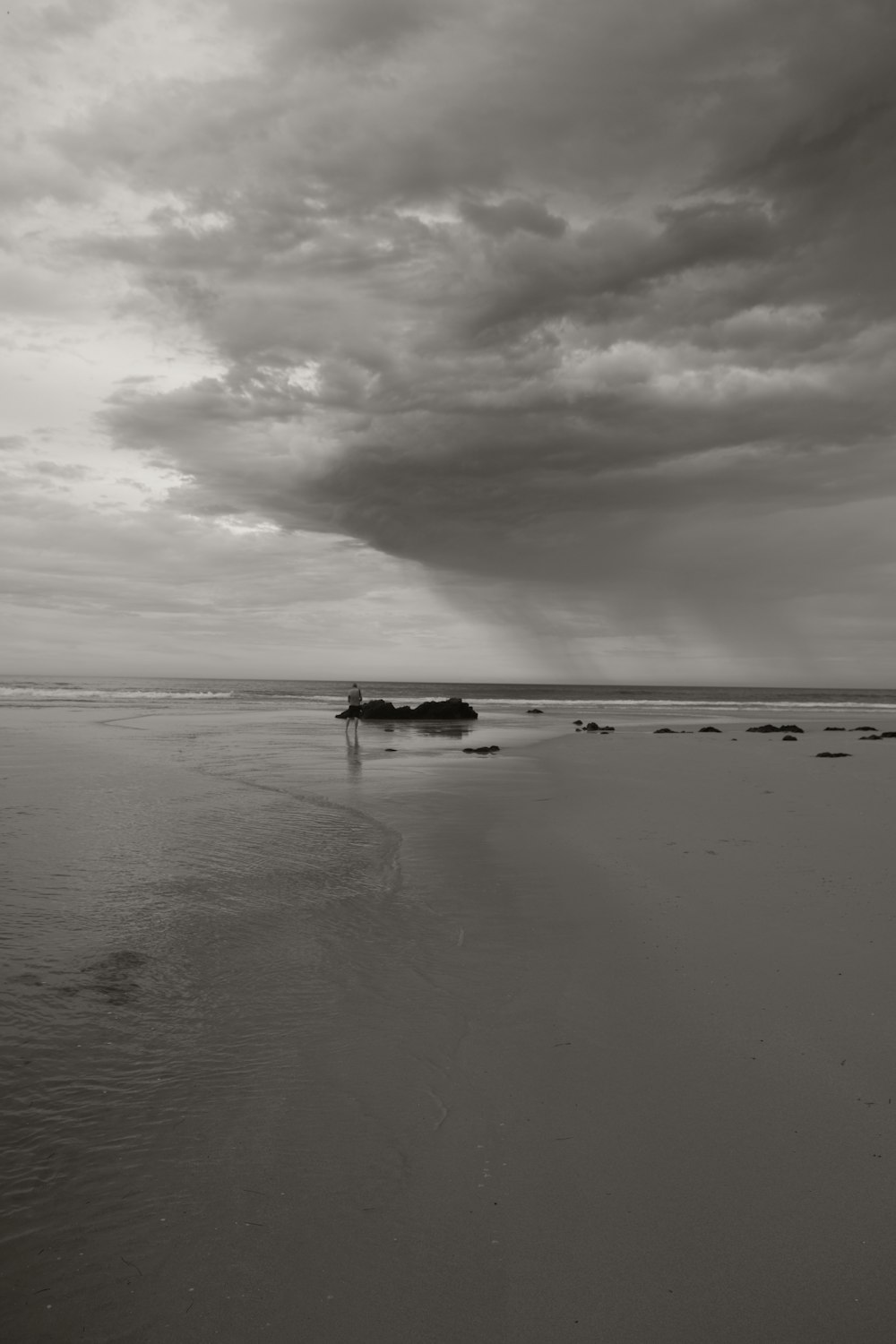 a black and white photo of a boat on the beach