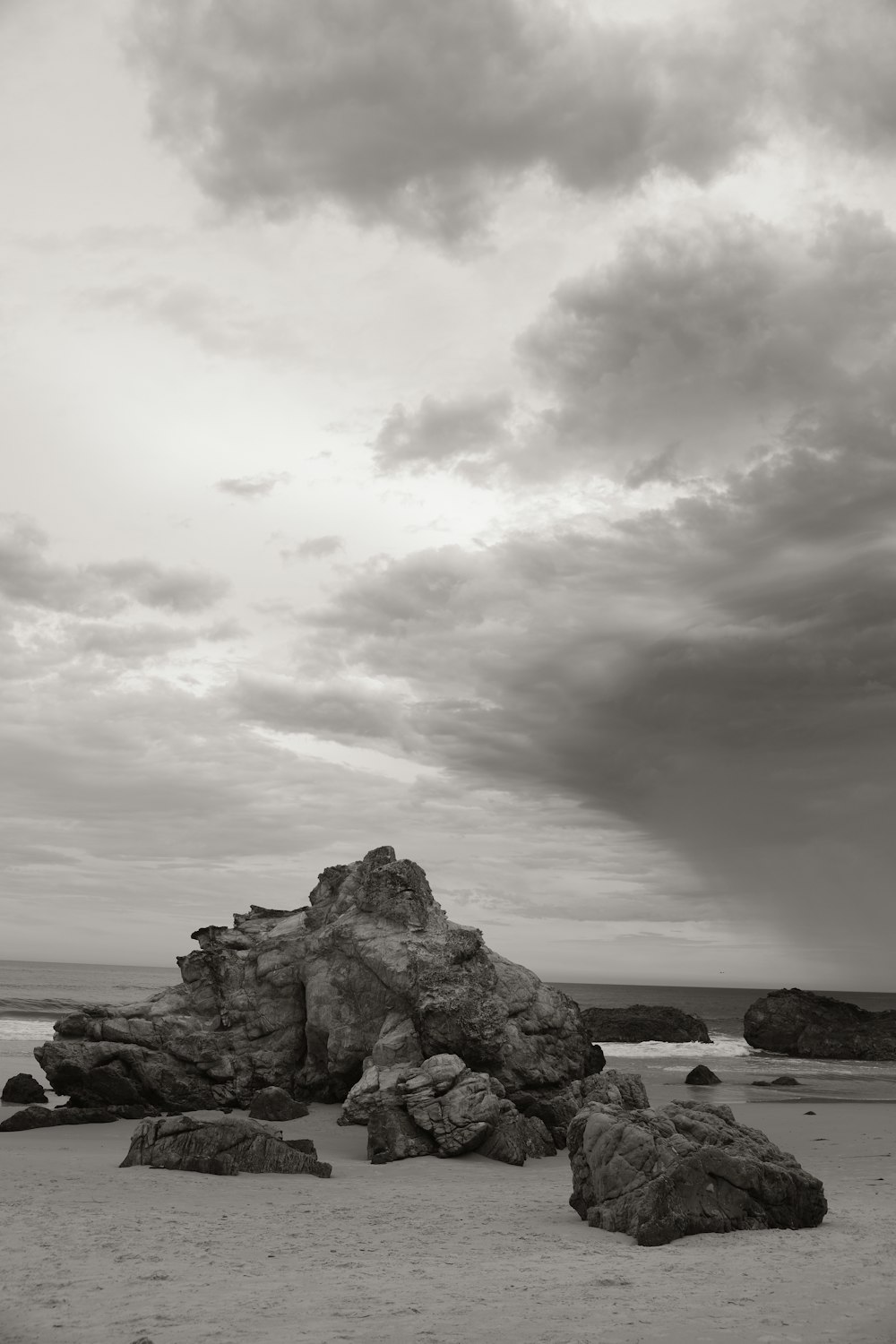 a black and white photo of rocks on a beach