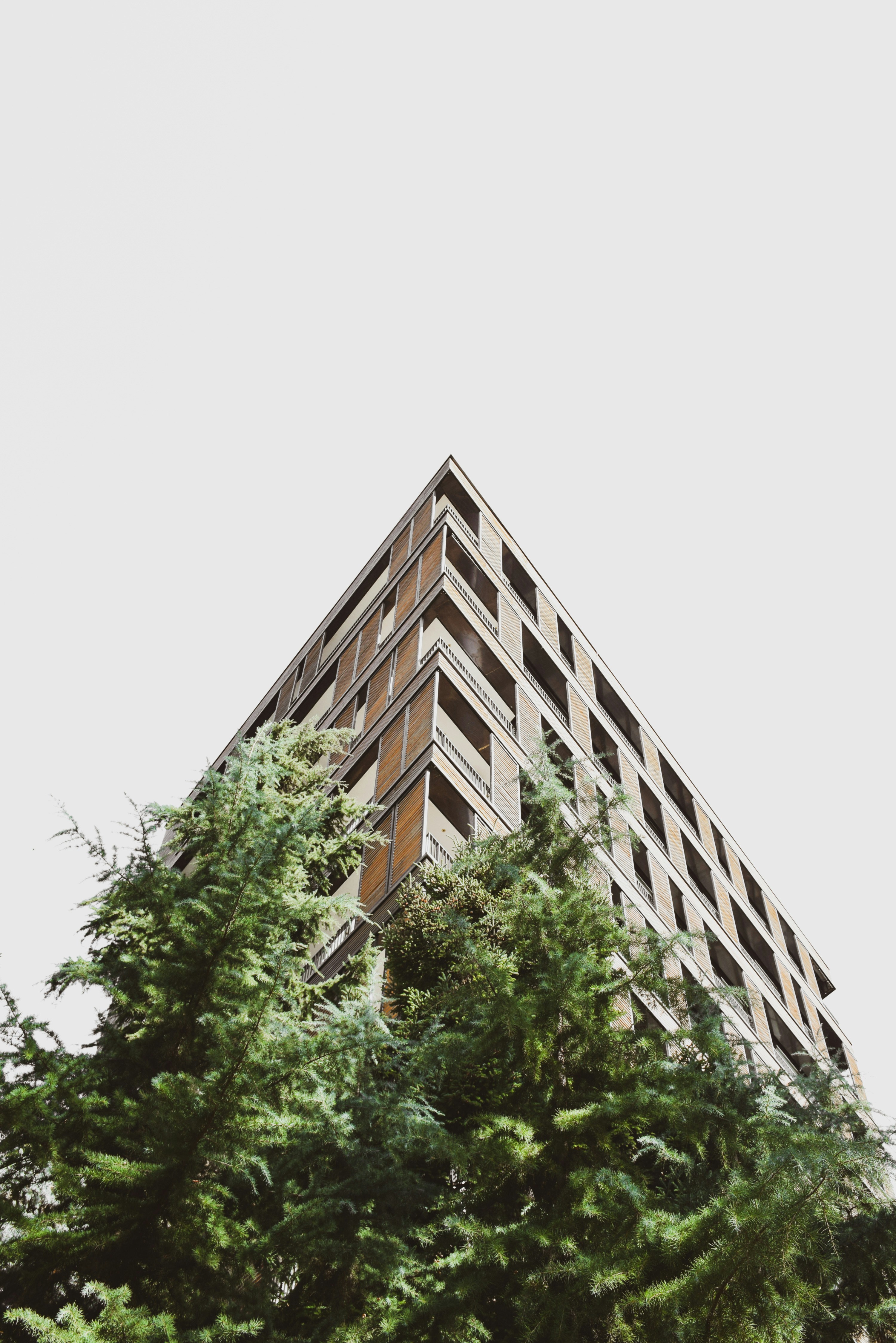 a tall building with lots of windows next to trees