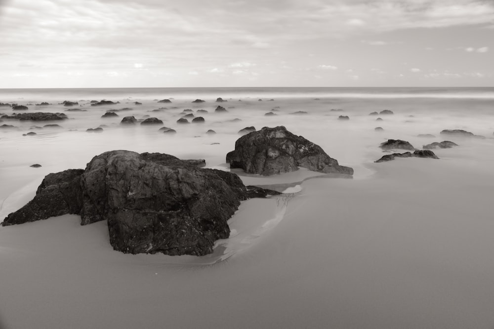 a black and white photo of rocks on a beach