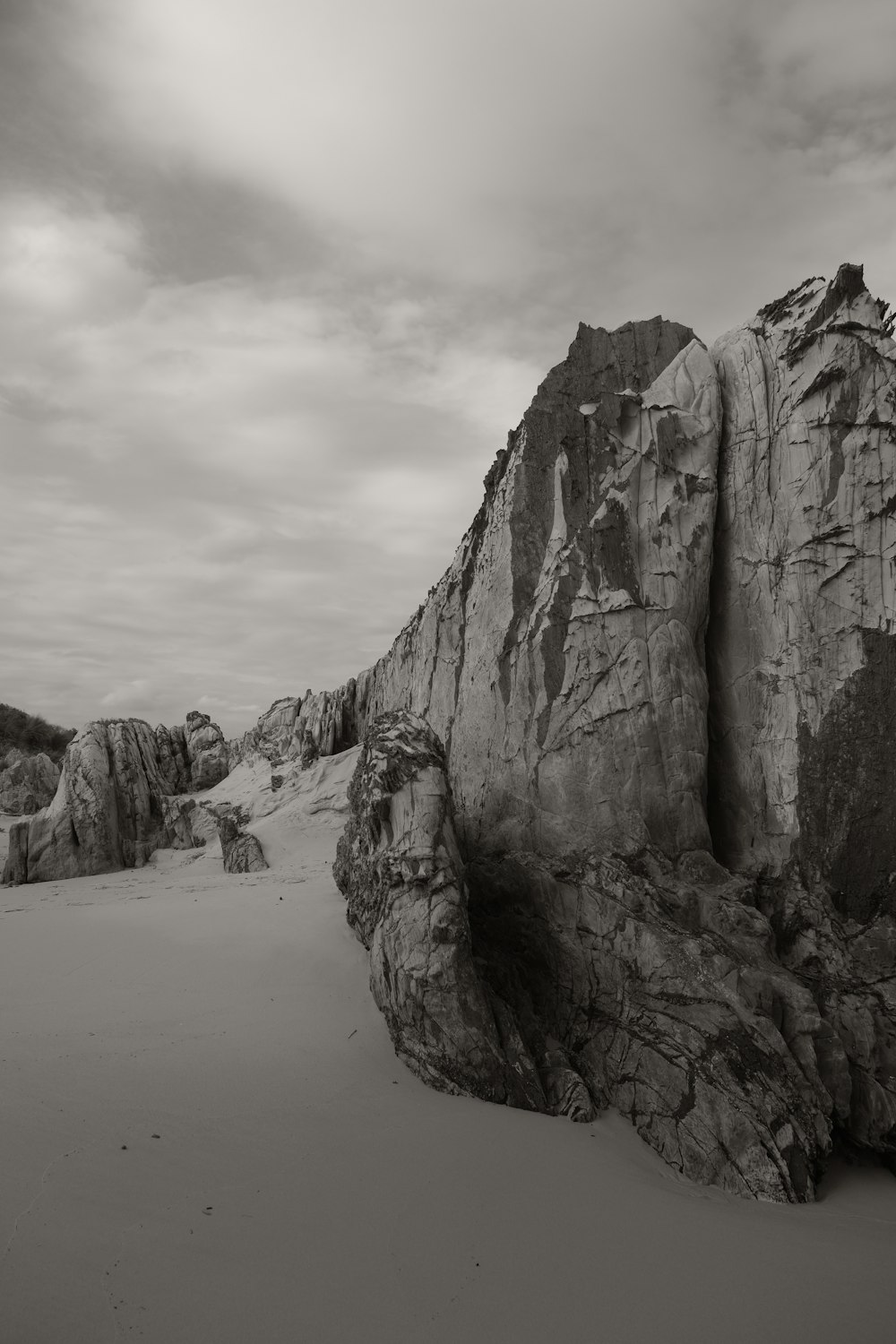 a large rock sitting on top of a sandy beach