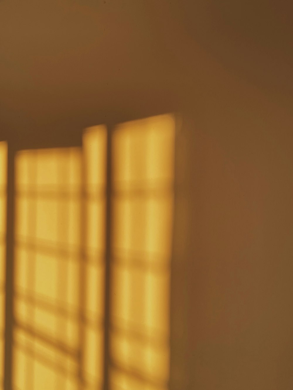 a bedroom with a bed and a window with sunlight coming through it