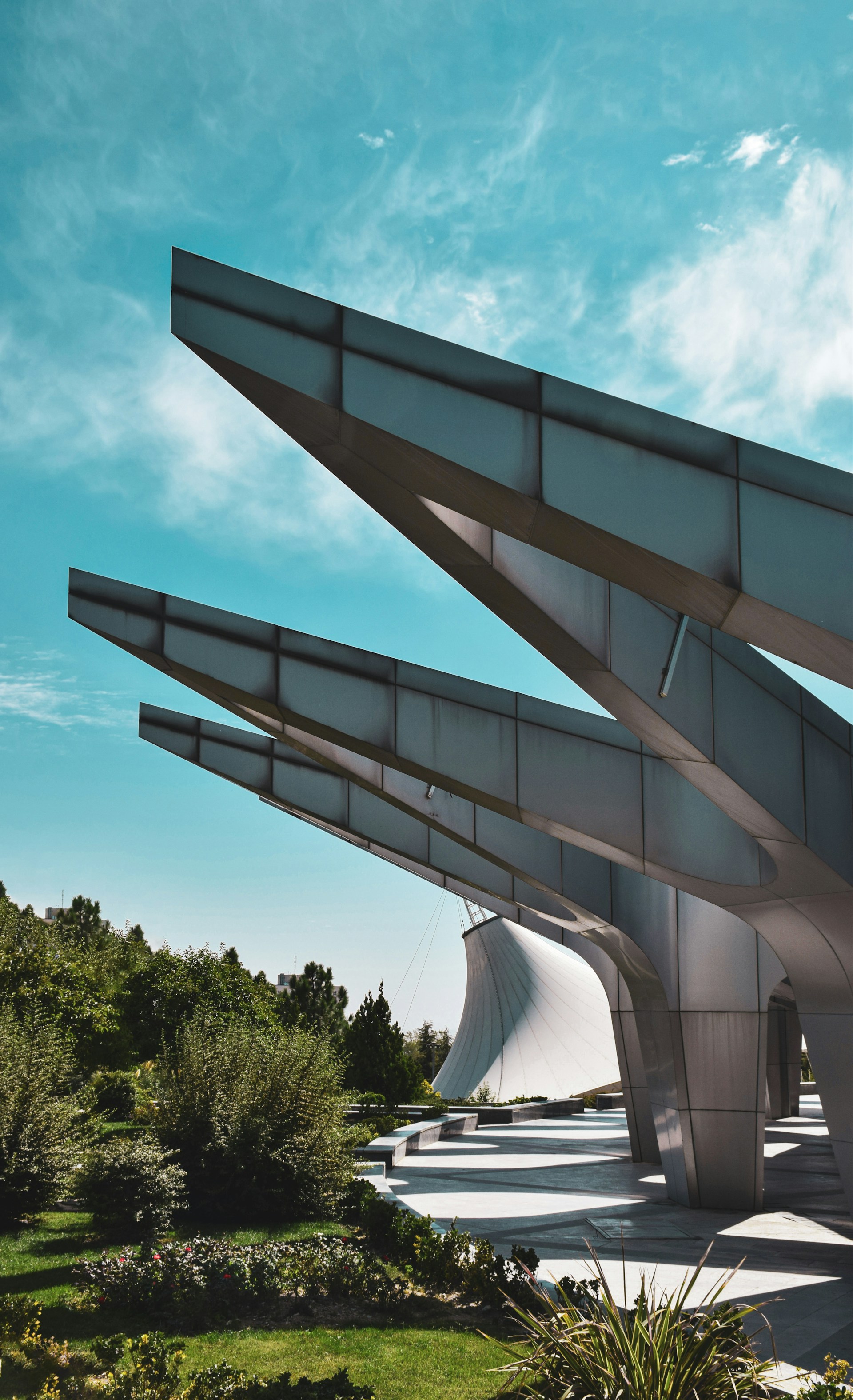 a large metal structure sitting on top of a lush green field