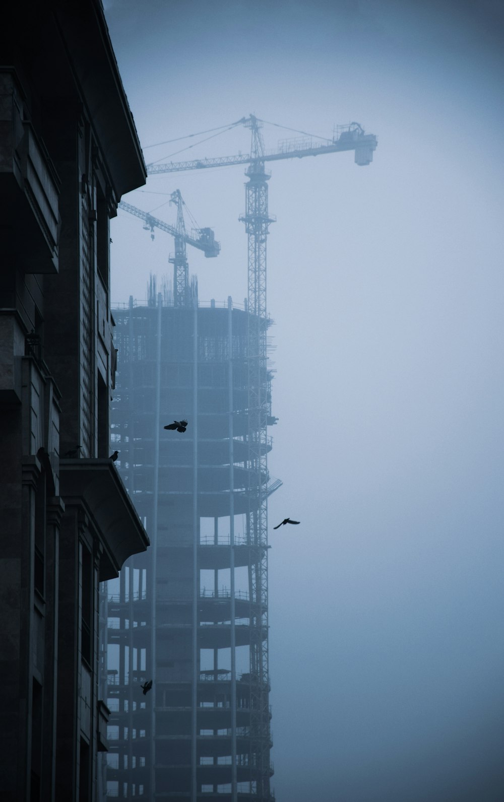 a building under construction with a crane in the background