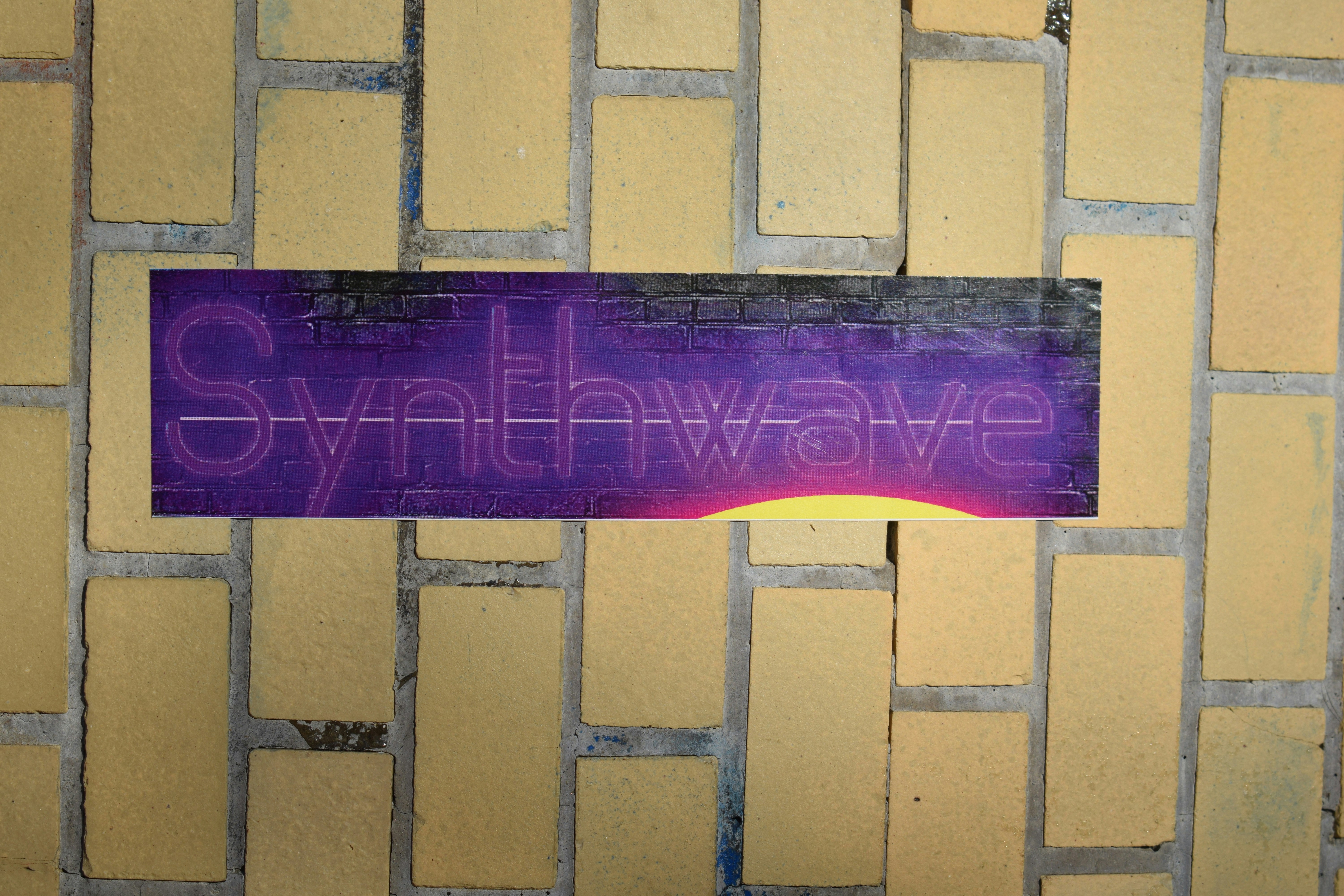 a purple street sign on a brick wall