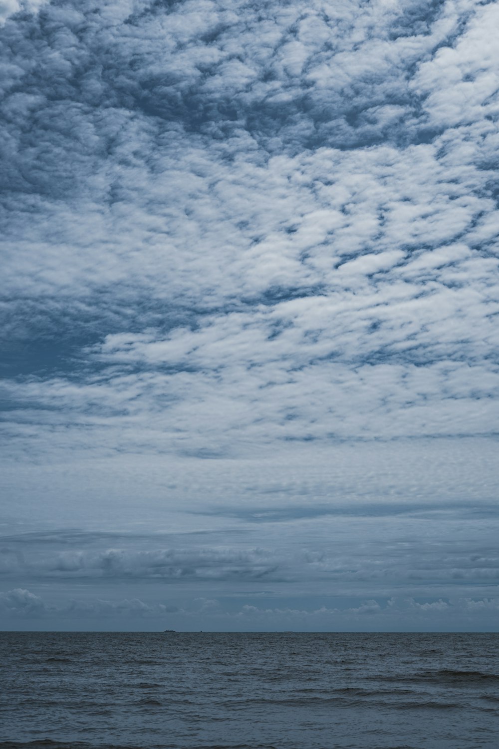 a person on a surfboard in the ocean under a cloudy sky