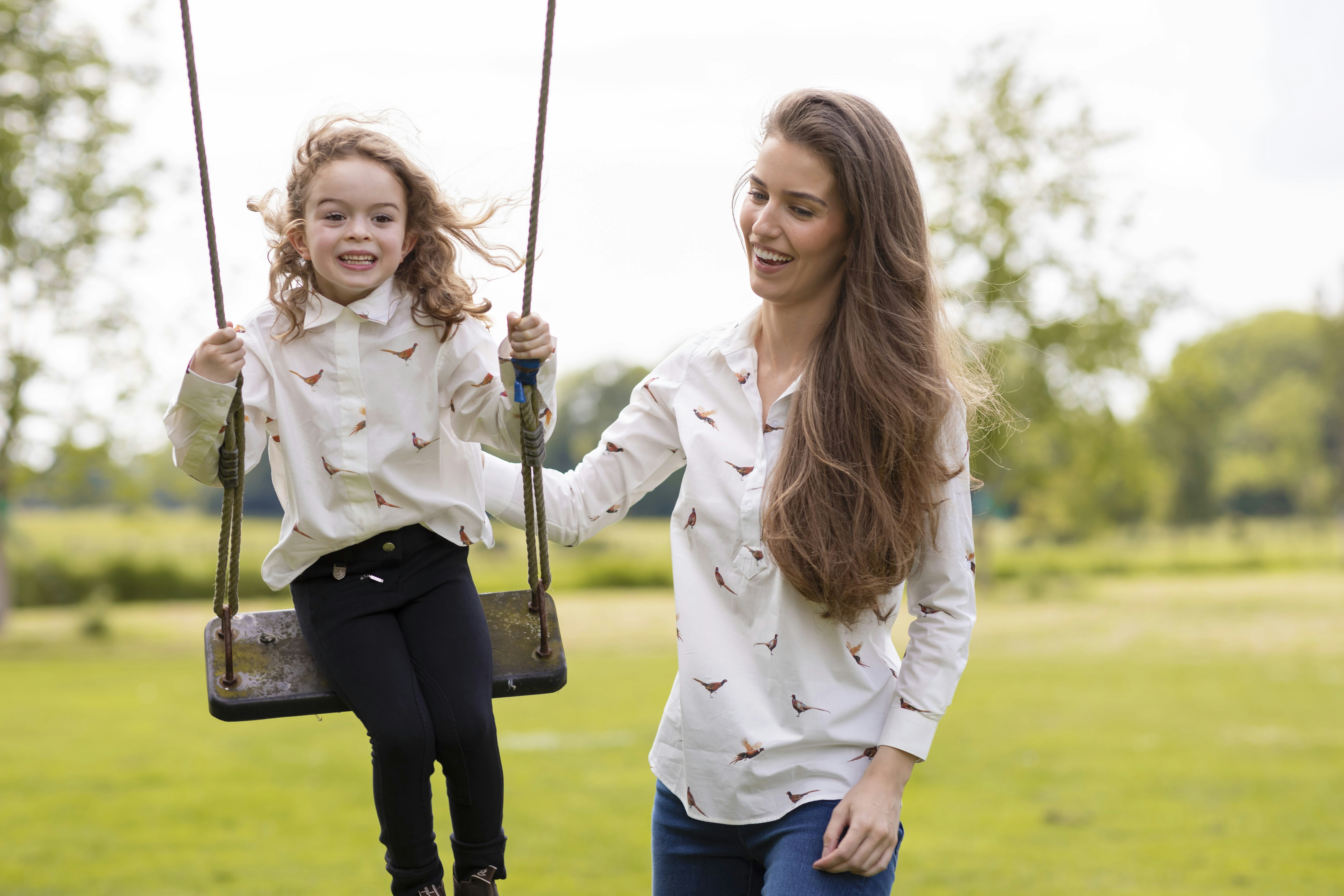 a woman and a little girl on a swing