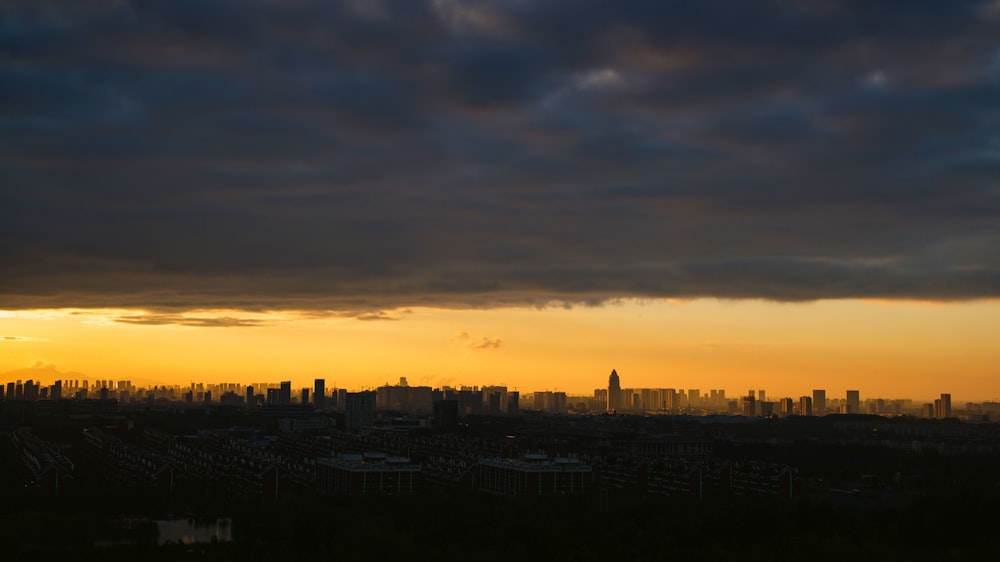 the sun is setting over a city with tall buildings