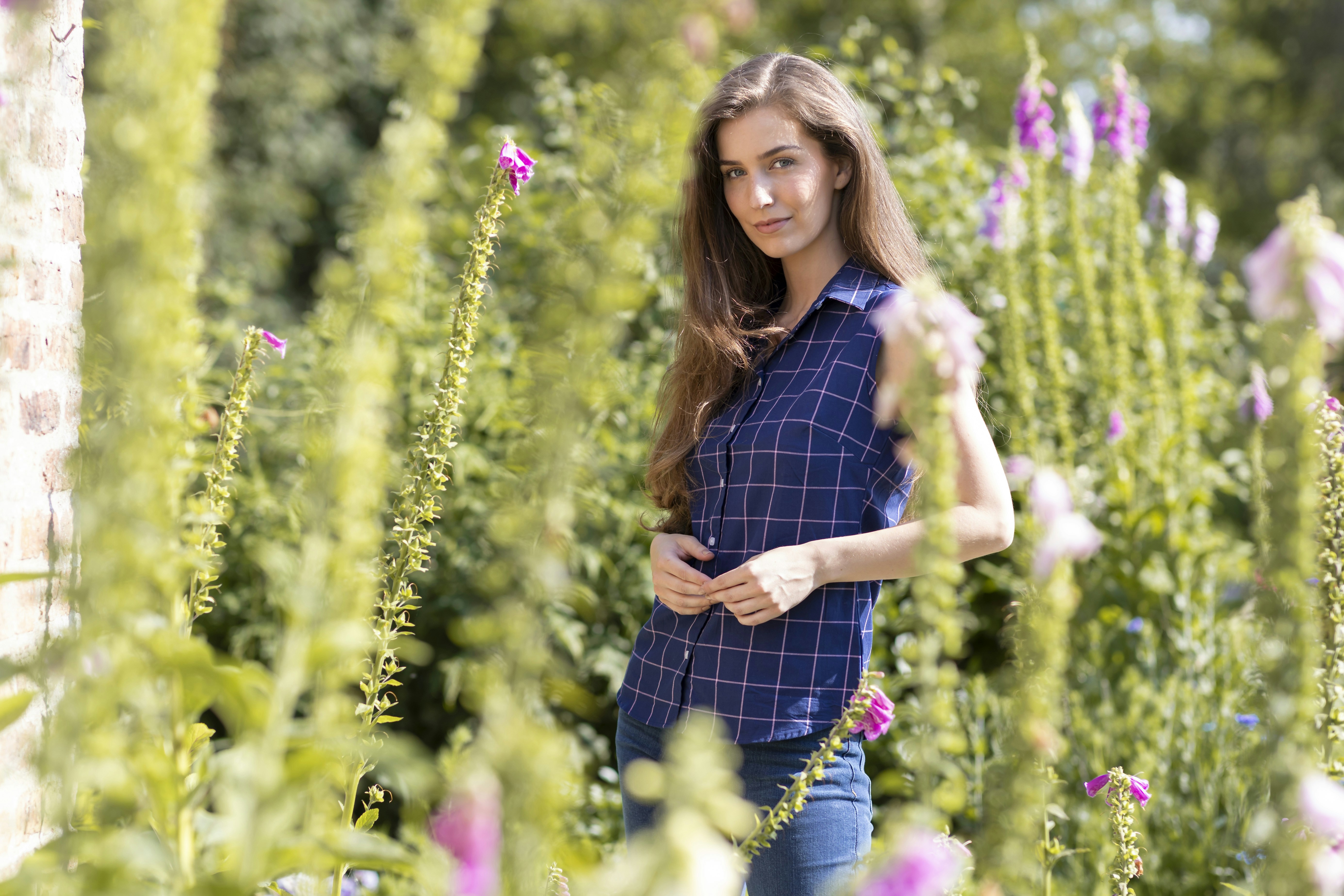 une femme debout dans un champ de fleurs