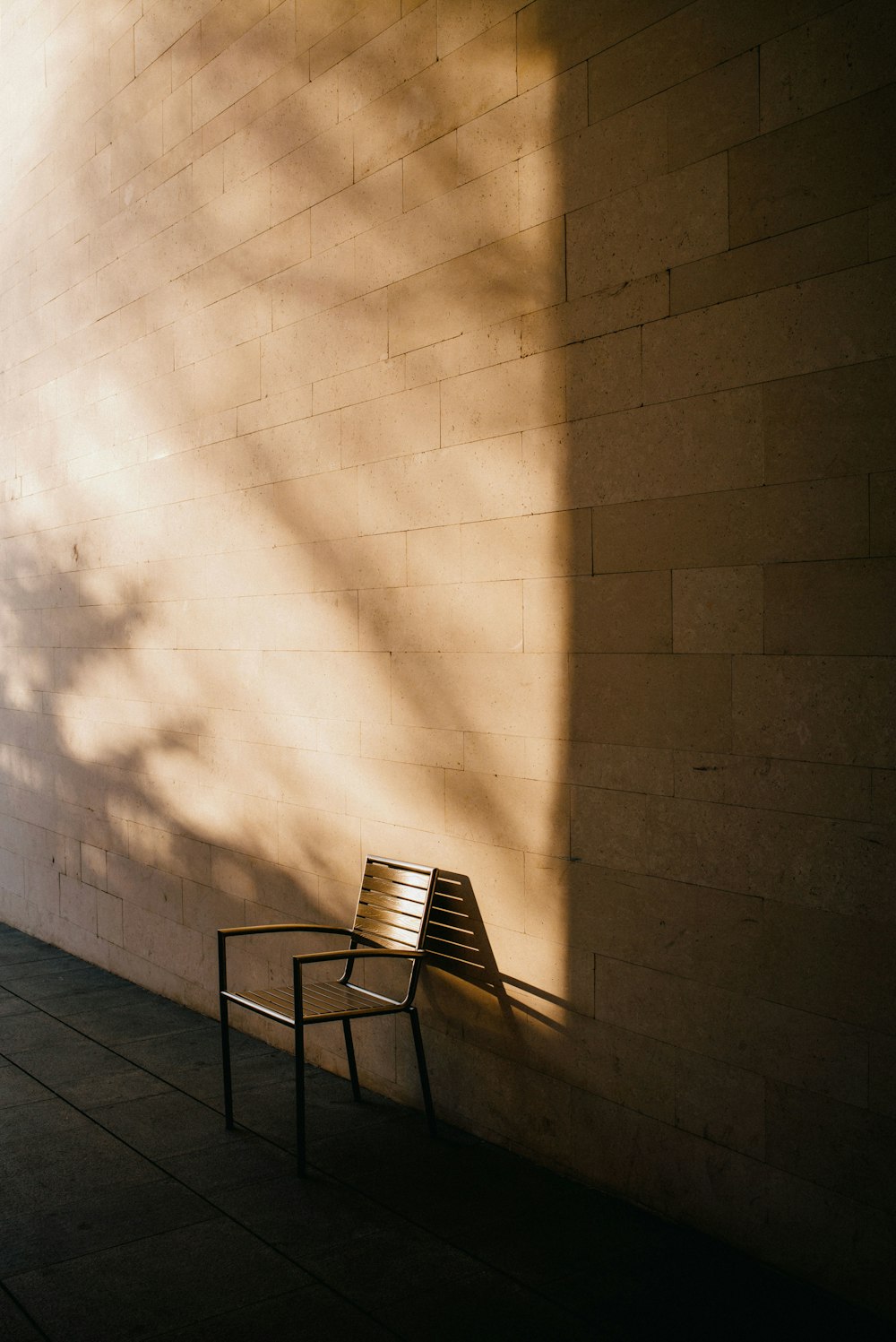 a wooden bench sitting next to a brick wall