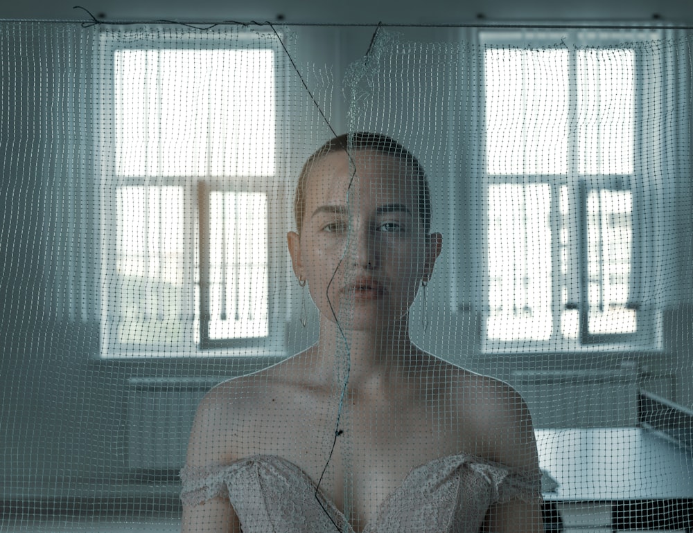 a woman standing in front of a window in a room