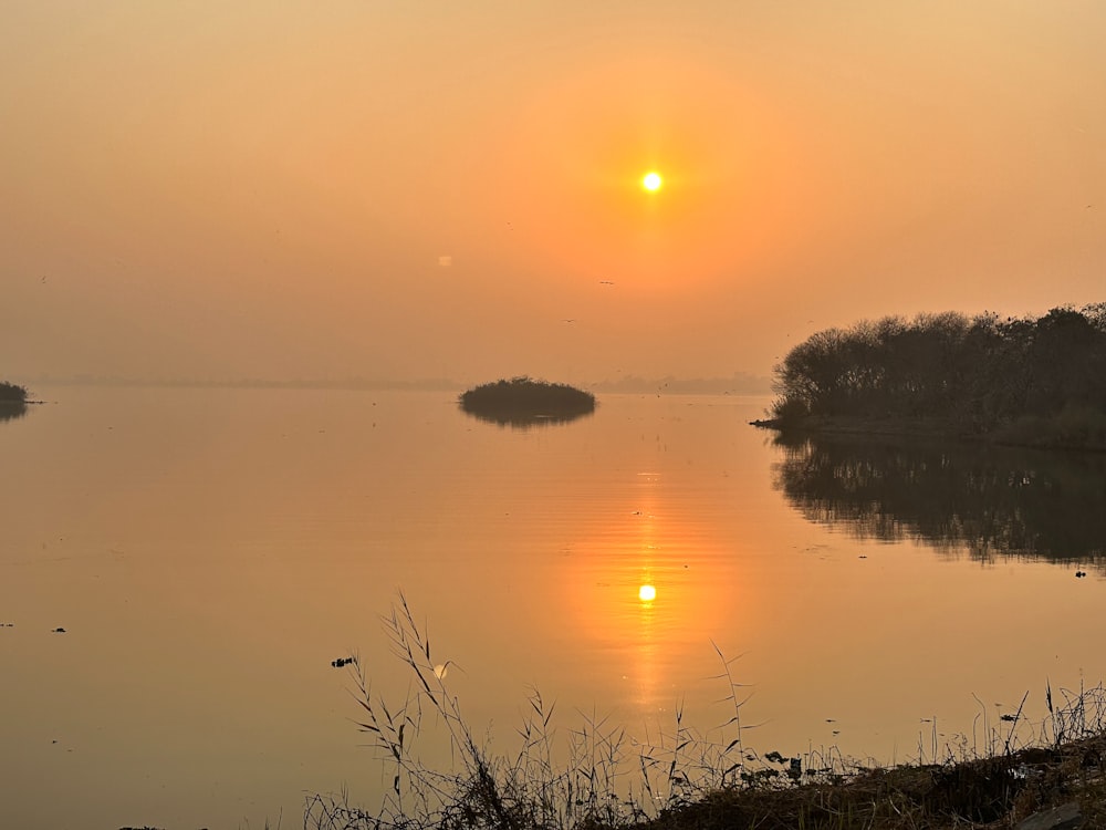 il sole sta tramontando su uno specchio d'acqua