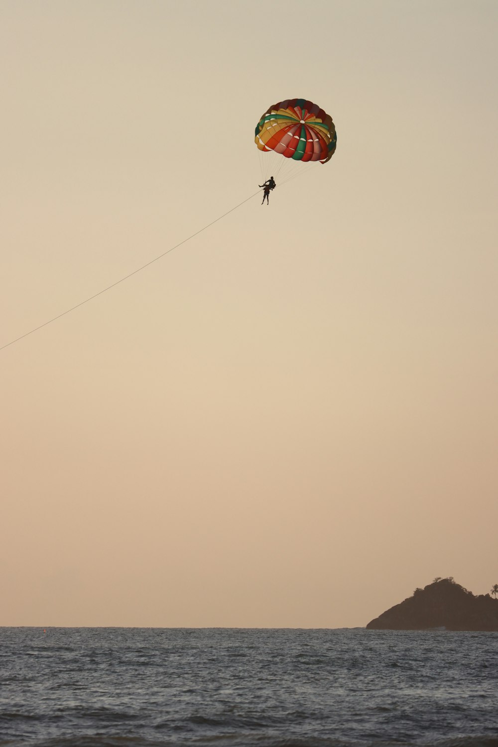 a person is parasailing in the ocean at sunset