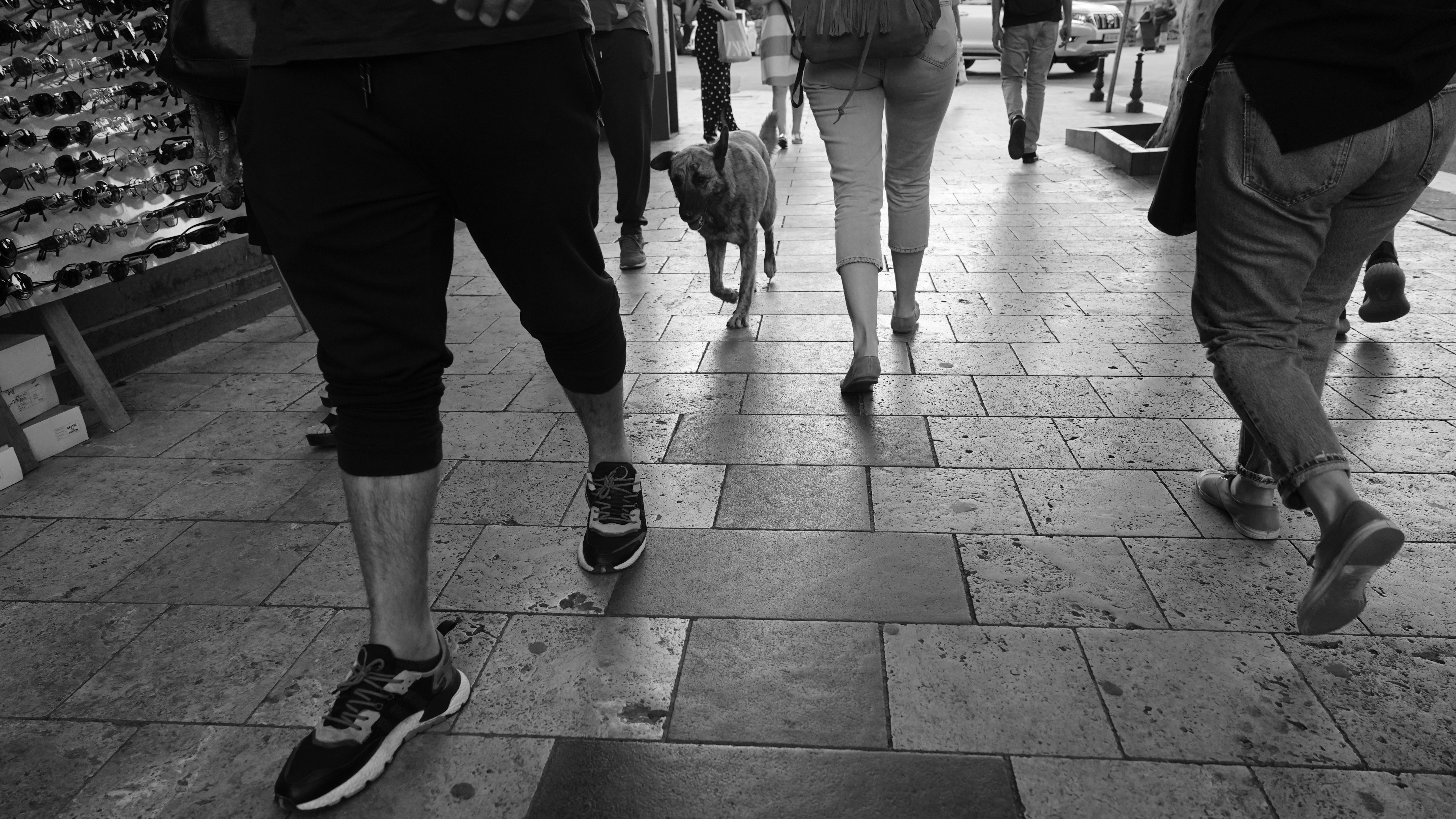 a group of people walking down a sidewalk