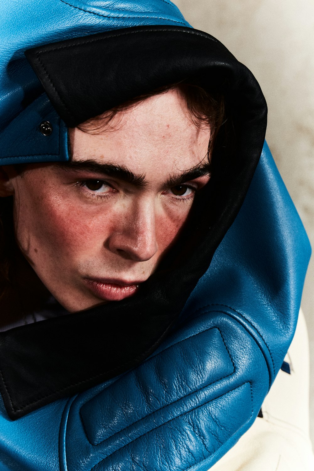 a young man wearing a blue hoodie with a black hood